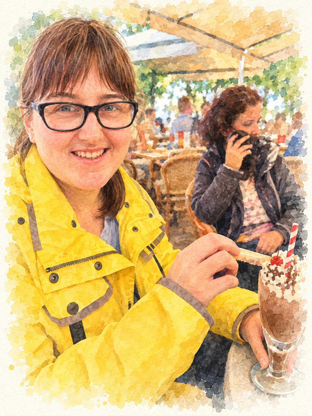 Eine lächelnde Frau in gelber Jacke genießt einen Schokoladen-Milchshake in einem gemütlichen Café